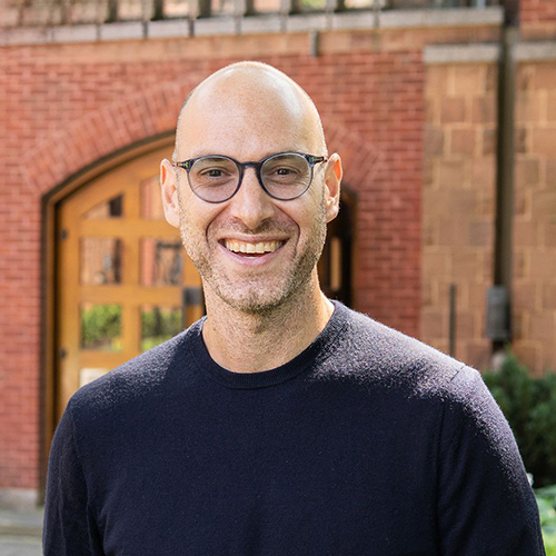 Gabriel Eidelman standing in front of building with wooden door.